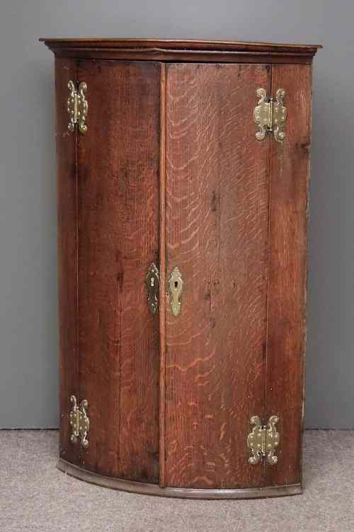 Appraisal: An th Century oak bow-fronted hanging corner cupboard with plain