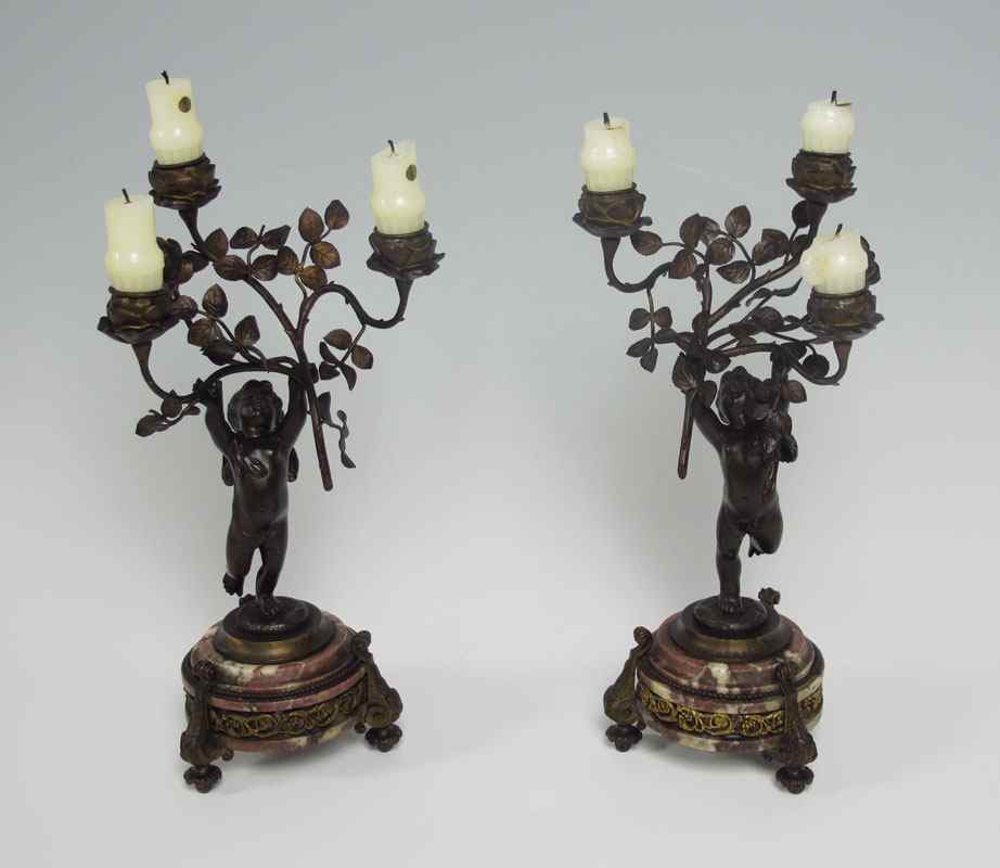 Appraisal: PAIR OF FRENCH BRONZE PUTTI CANDELABRA Winged cherubs support the