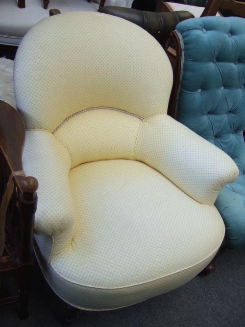 Appraisal: A Victorian upholstered tub chair with scroll over arms on