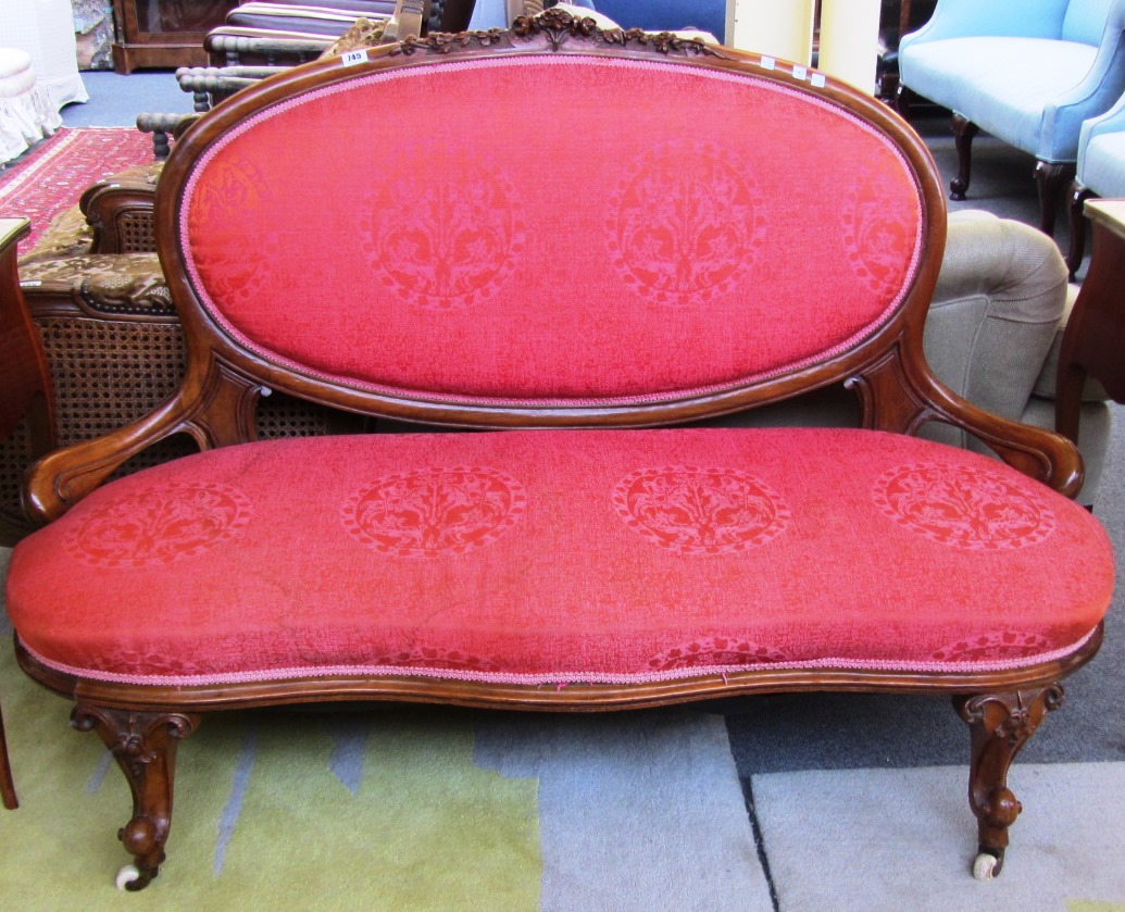 Appraisal: A Victorian walnut salon sofa with low downswept arms and