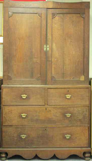 Appraisal: An oak linen press the top fitted sliding trays enclosed