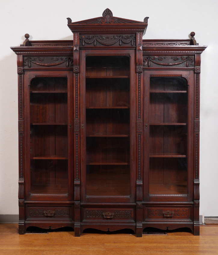 Appraisal: CARVED VICTORIAN TRIPLE DOOR BOOKCASE Center with carved crest of