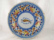 Appraisal: A tin glazed ceramic charger brightly enamelled and with a