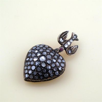 Appraisal: A heart shaped pendant pav set with flat diamonds Suspended