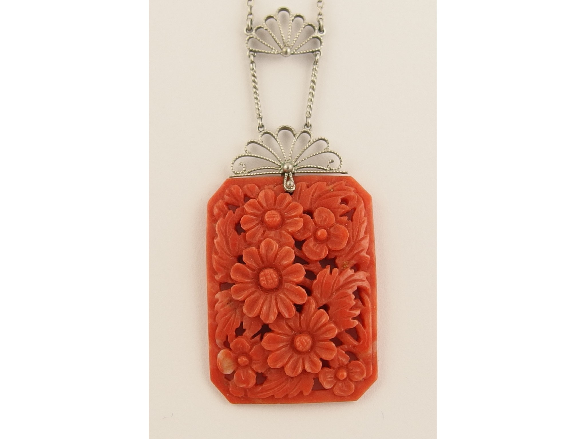 Appraisal: A 's carved coral pendantcarved with flowers and foliage with