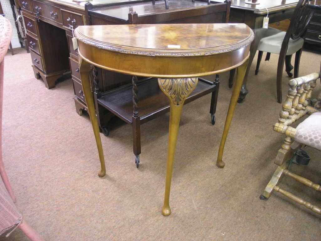 Appraisal: A burr walnut veneered demi-lune hall table on cabriole legs