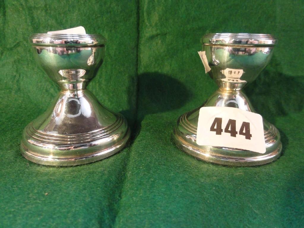 Appraisal: A small pair of silver squab candlesticks with reeded borders