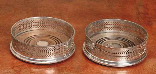 Appraisal: A PAIR OF SILVER BOTTLE COASTERS with pierced and beaded