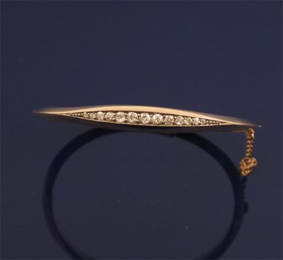 Appraisal: A gold hinged bangle Set with graduated circular cut diamonds