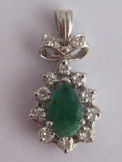 Appraisal: A white metal tests carat gold emerald and diamond pendant