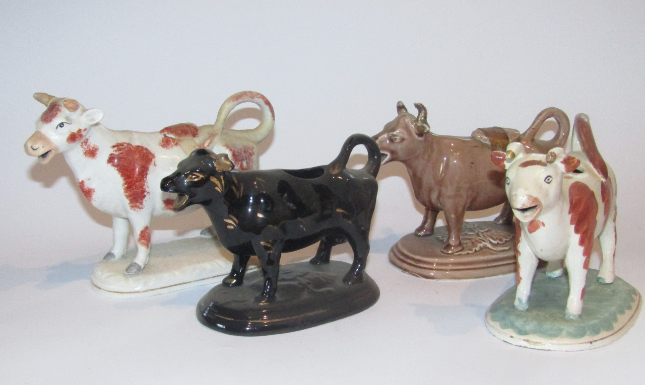 Appraisal: A thC Staffordshire cow creamer with tail handle and stopper