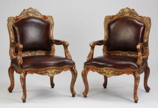 Appraisal: Carved mahogany armchairs in leather Pair of carved and parcel