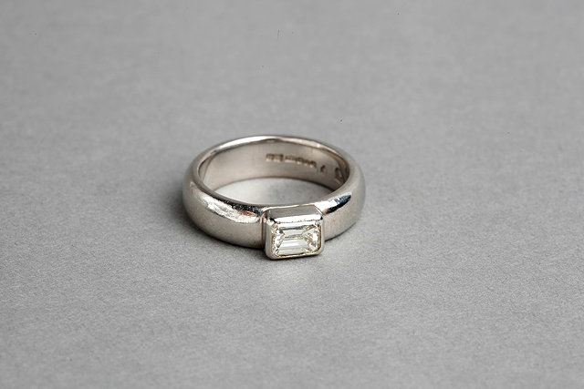 Appraisal: A SOLITAIRE DIAMOND RING baguette diamond mounted in a rub