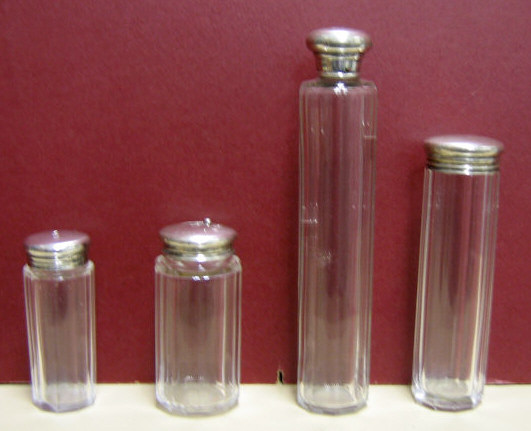 Appraisal: FOUR ENGLISH GLASS AND SILVER VANITY BOTTLES Each cut glass