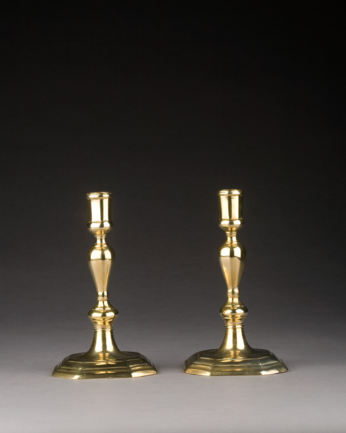 Appraisal: PAIR OF GEORGE II BRASS CANDLESTICKS CIRCA Each faceted cushioned