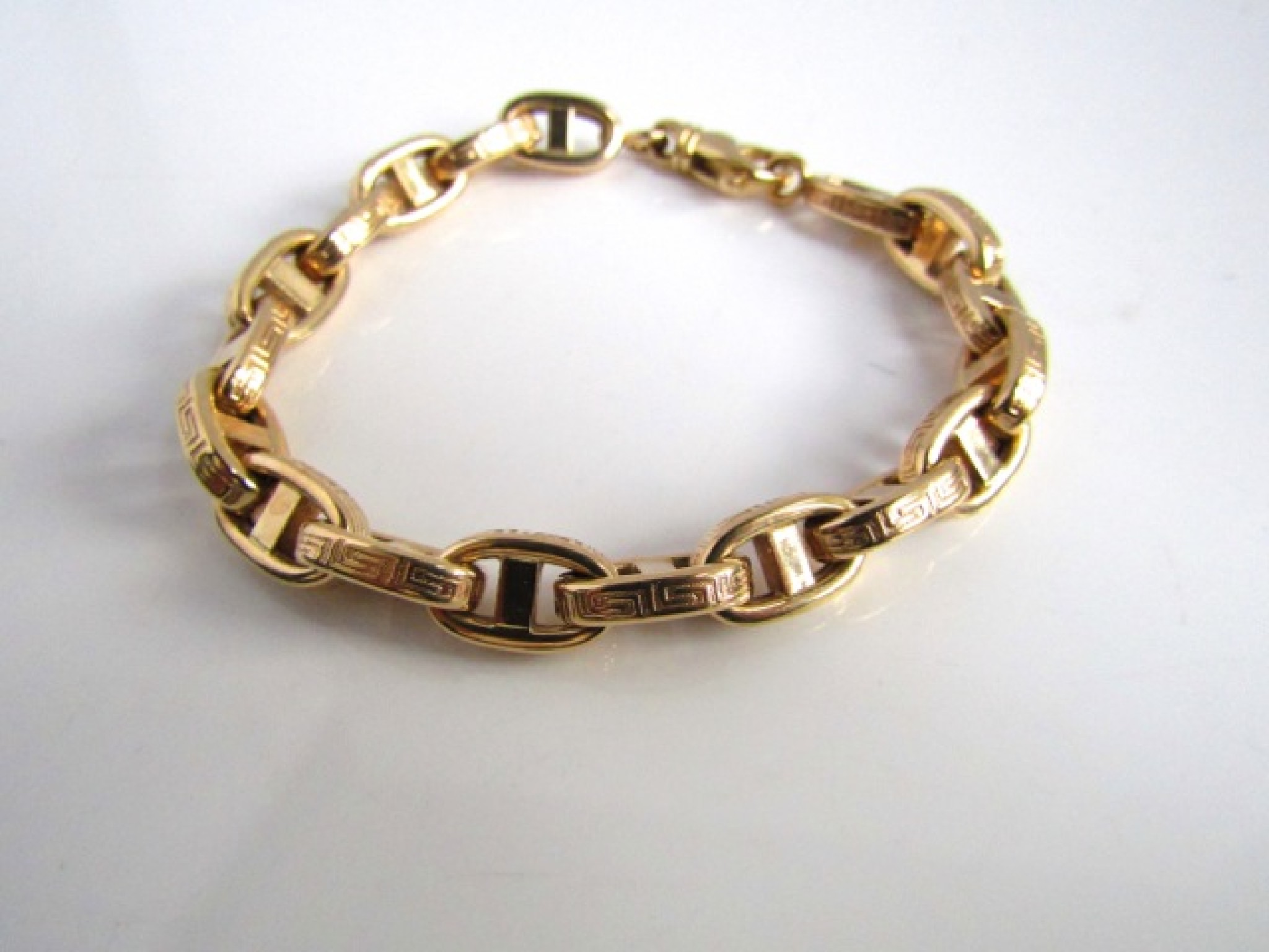 Appraisal: A ct gold Gucci-link bracelet each link with Greek Key