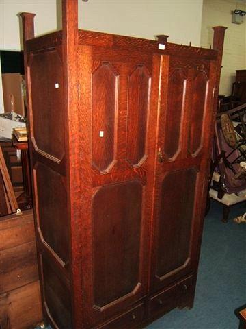 Appraisal: An Arts and Crafts oak wardrobe with twin panelled doors