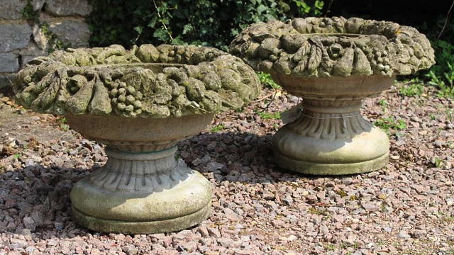 Appraisal: A PAIR OF CAST CONCRETE URNS or planters with flower