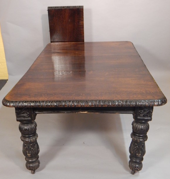 Appraisal: A Victorian ebonised oak extending dining table the top with