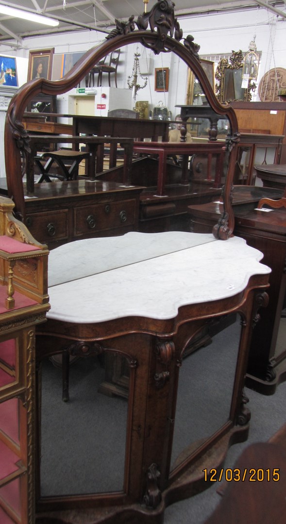 Appraisal: A Victorian mirrored back sideboard with serpentine marble top over