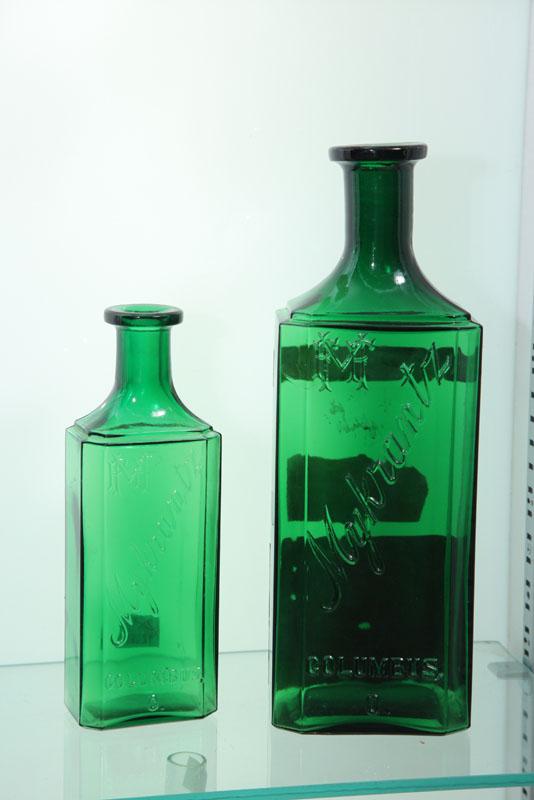 Appraisal: TWO DRUGGIST BOTTLES Dark green bottles wth embossed lettering Mykrantz