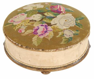 Appraisal: A Victorian large circular footstool with a floral needlework top