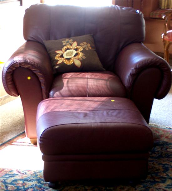 Appraisal: Cordovan leather chair and matching ottoman on casters some wear