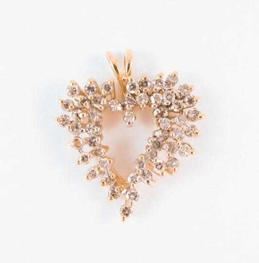 Appraisal: DIAMOND AND TEN KARAT GOLD PENDANT The open heart pendant