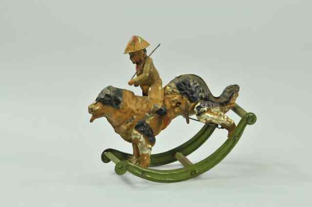 Appraisal: BOY RIDING DOG Germany hand painted tin amusing clockwork driven