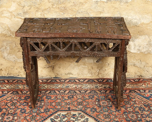 Appraisal: A BENIN CARVED RECTANGULAR TABLE with stylised figure decoration and