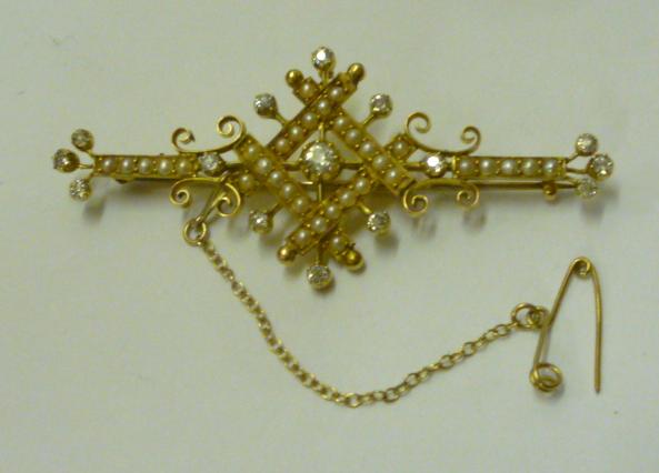 Appraisal: A VICTORIAN DIAMOND AND HALF PEARL BROOCH the openwork gold