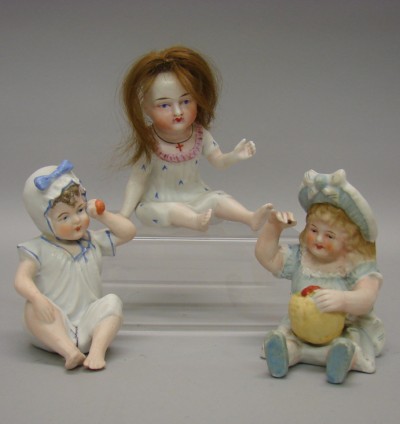 Appraisal: Lot of Unmarked bisque sitting female piano babies Holding a