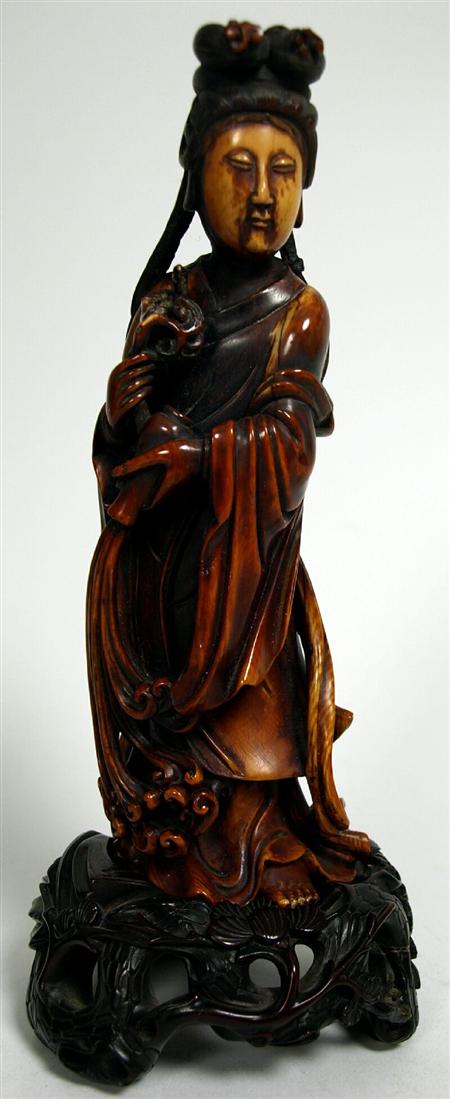 Appraisal: A th century Chinese stained ivory Guanyin figure holding a