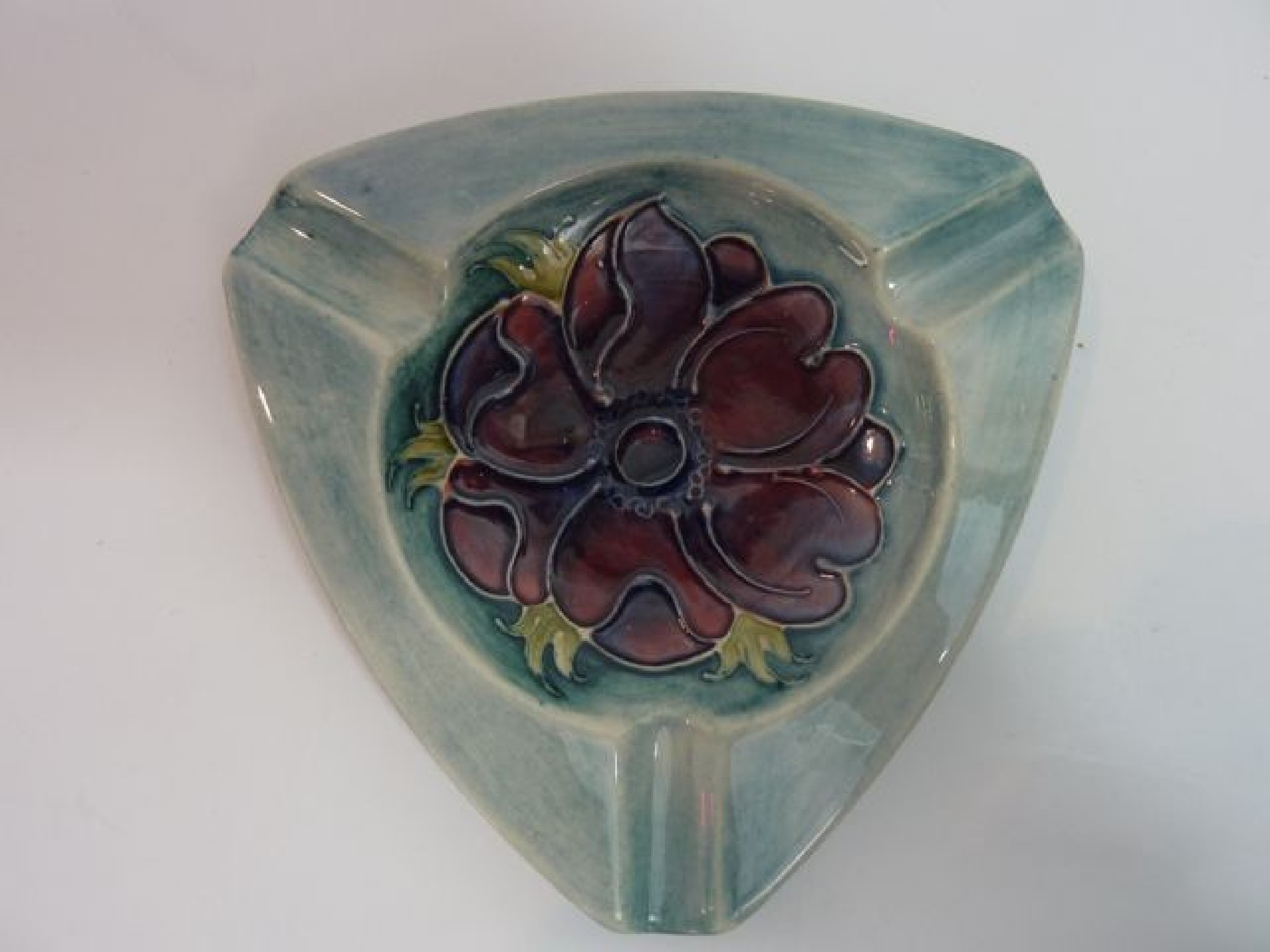 Appraisal: A Moorcroft blue ground ashtray of triangular form with painted