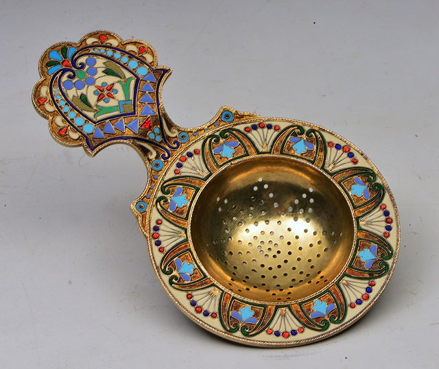 Appraisal: A RUSSIAN SILVER TEA STRAINER with stylised handle and profuse