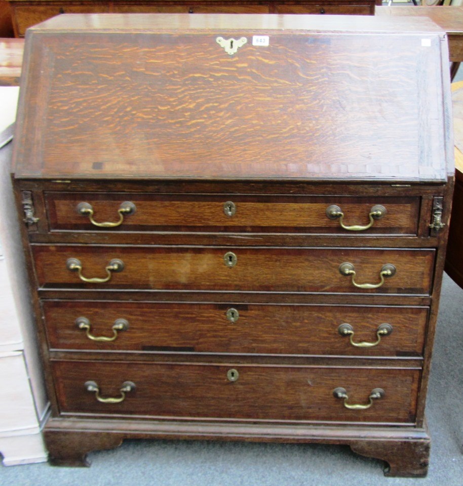 Appraisal: A George III oak bureau the fall enclosing a fitted