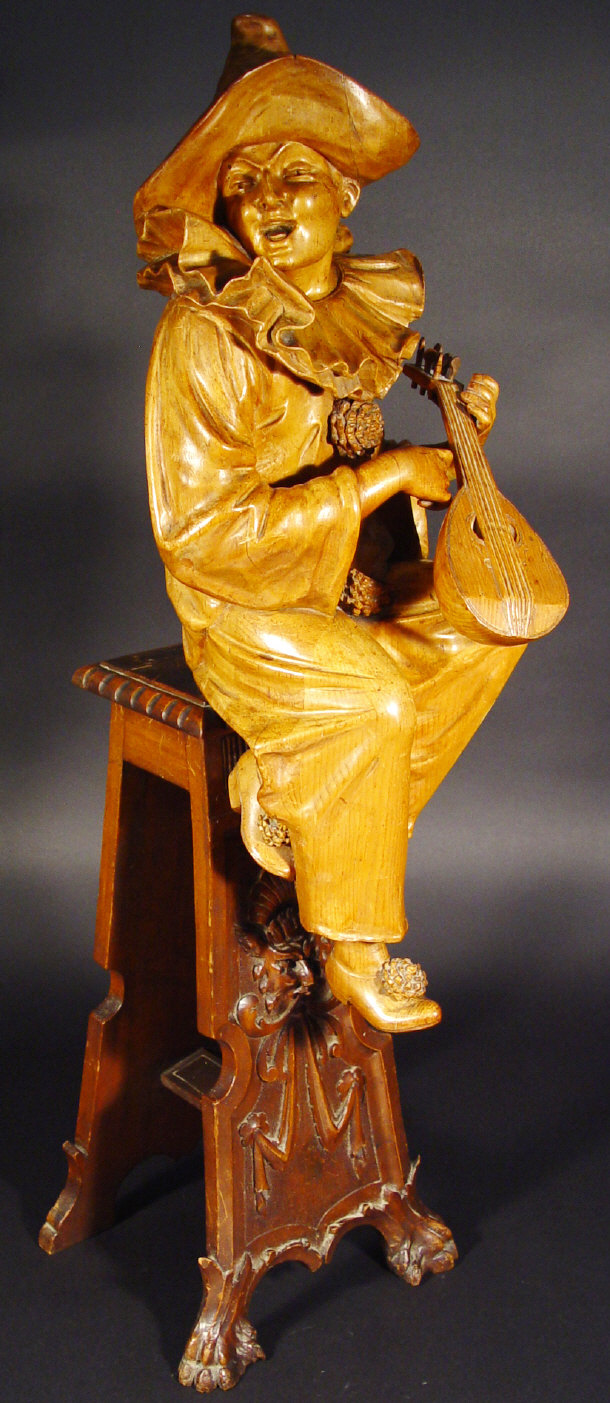 Appraisal: Italian carved fruitwood Troubadour playing a mandolin seated on a