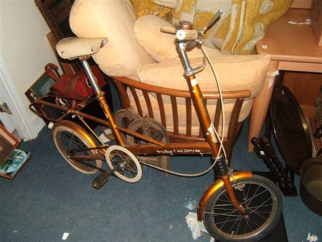 Appraisal: A Moulton bicycle with gold frame and small diameter wheels