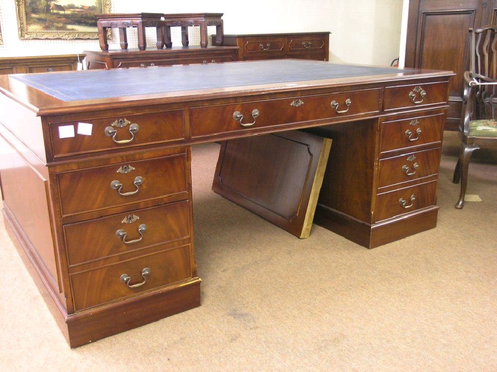 Appraisal: A large reproduction mahogany partner's desk with inset gilt tooled