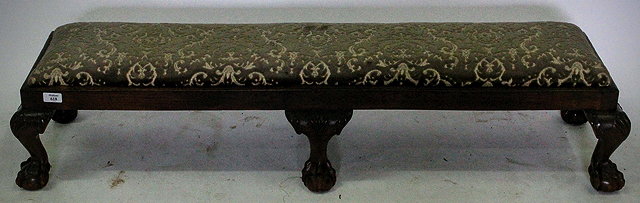 Appraisal: A LONG LOW MAHOGANY FRAMED FOOTSTOOL with an upholstered inset