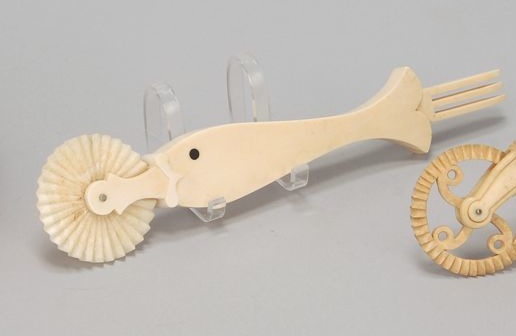 Appraisal: WHALE IVORY JAGGING WHEEL th CenturyIn fish form with ebony