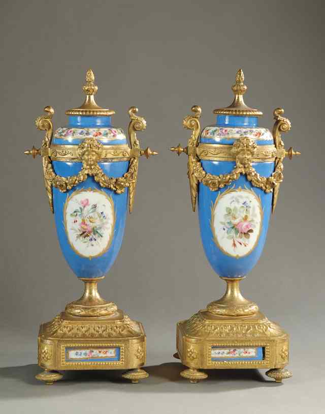 Appraisal: FRENCH PAIR PORCELAIN COVERED URNS in the Sevres style with