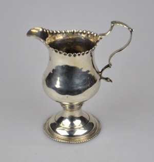 Appraisal: A George III silver baluster cream jug with scroll handle