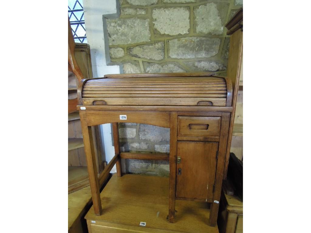 Appraisal: A child's kneehole single pedestal roll top desk raised on