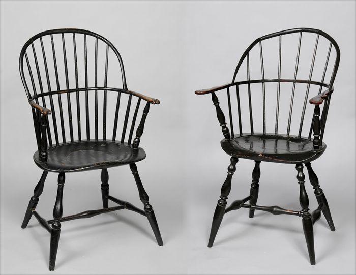 Appraisal: TWO WINDSOR BLACK-PAINTED SACK-BACK ARMCHAIRS Each with arched crest over