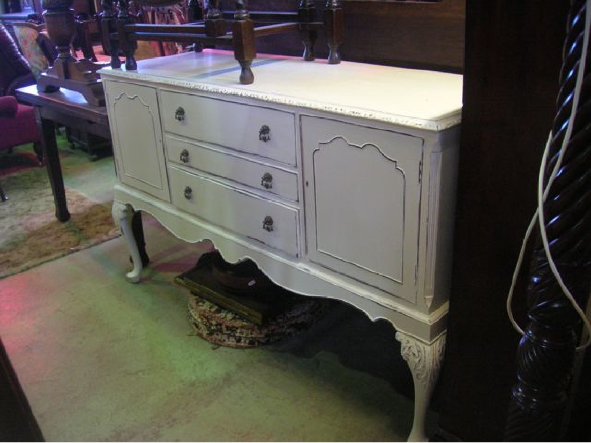 Appraisal: A reproduction 'shabby chiced' sideboard fitted with three long central