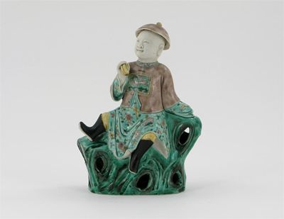 Appraisal: A Chinese famille verte figure of a boy seated on