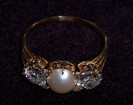 Appraisal: A three-stone ring the central split pearl flanked by two