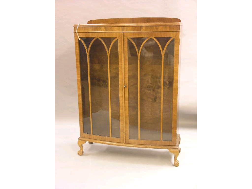 Appraisal: A walnut veneered display cabinet bow fronted having a pair