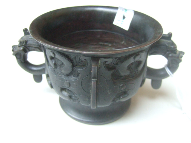 Appraisal: A small Chinese bronze two-handled bowl worked in archaic style